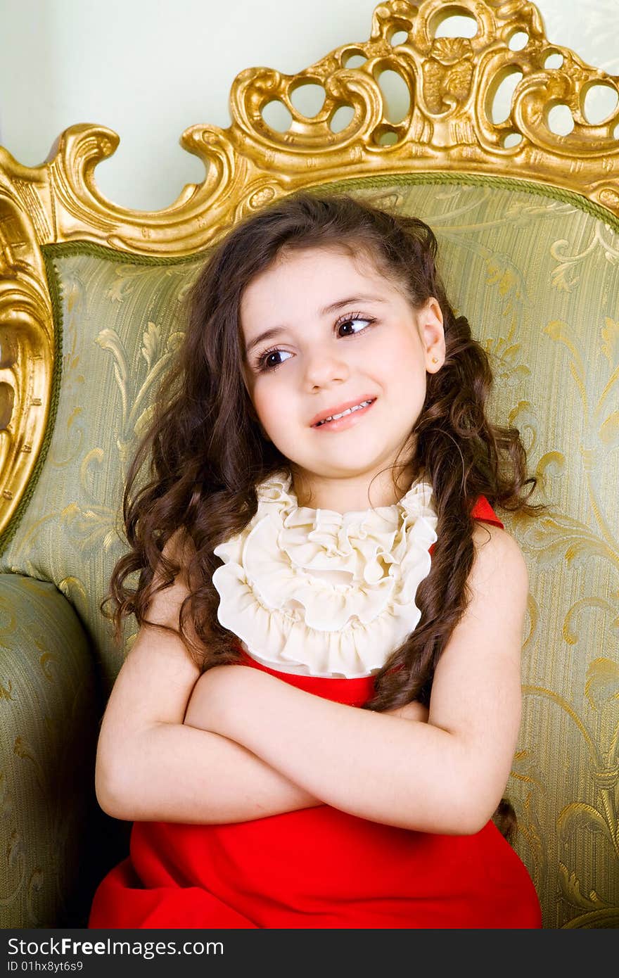 Small girl with long hair in the armchair