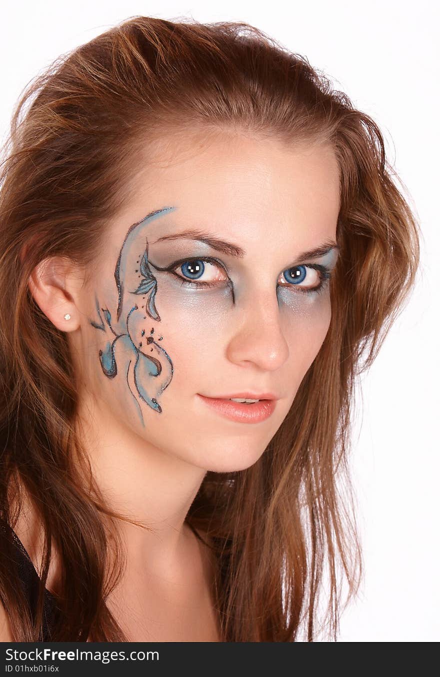 Brunette with brown hair face painted with beautiful patterns and matching eyes