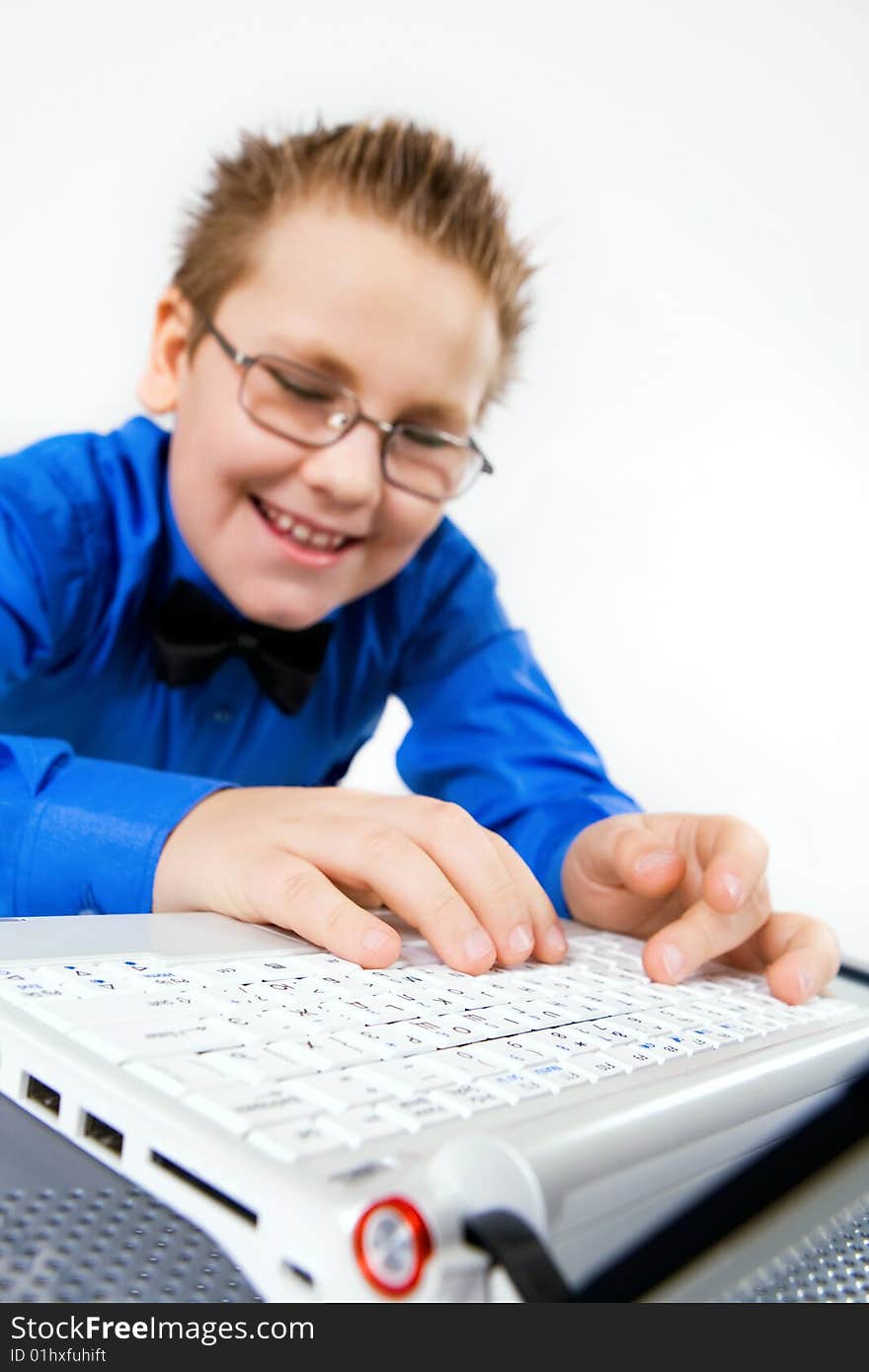 Funny school boy with with fingers on laptop keyboard. Funny school boy with with fingers on laptop keyboard