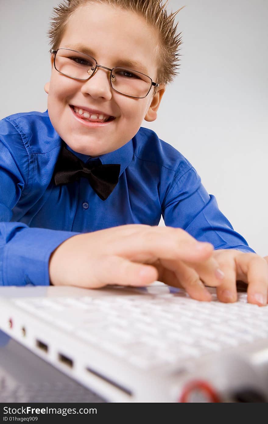 Funny school boy with with fingers on laptop keyboard. Funny school boy with with fingers on laptop keyboard