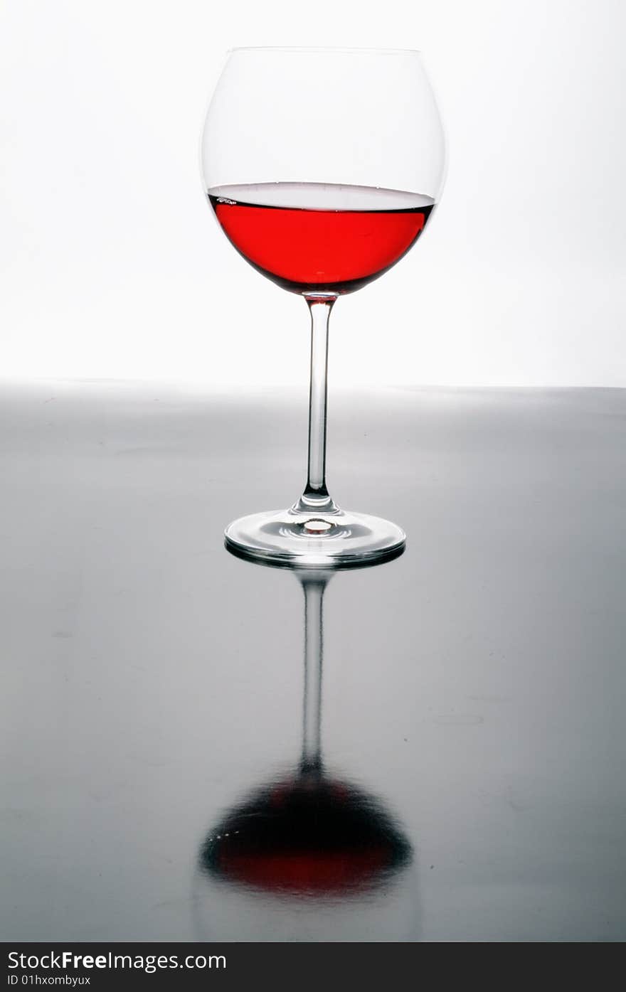 A glass of red wine on grey isolated on white with reflection