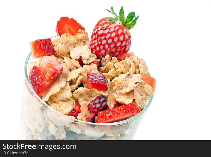 Bowl with corn flakes and strawberry served with milk