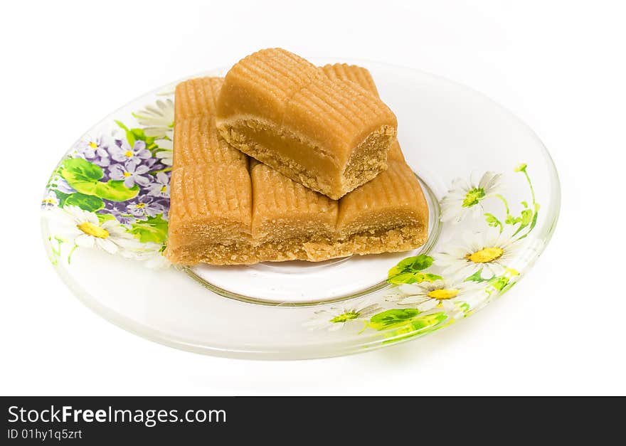 Several toffee in plate on tea saucer decorated flowers