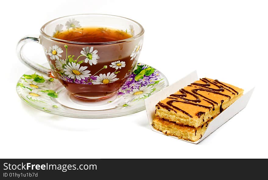 Cap of tea on saucer with cake on white