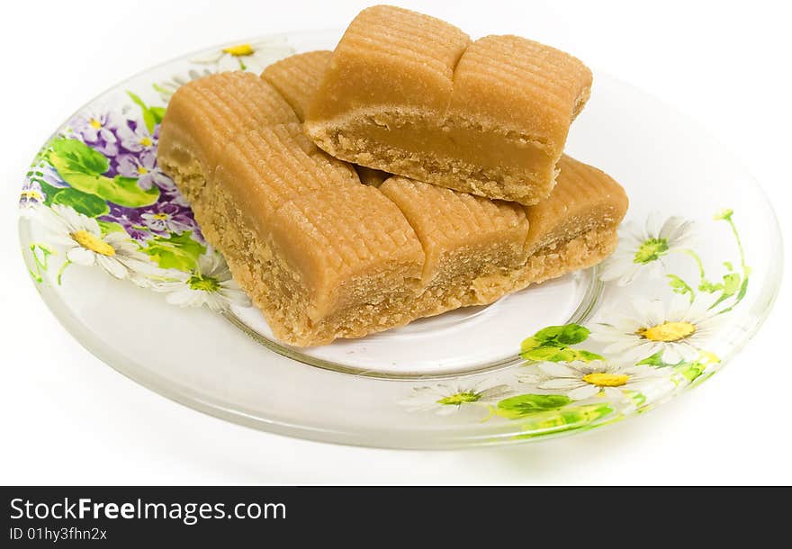 Several toffee in plate on tea saucer decorated flowers