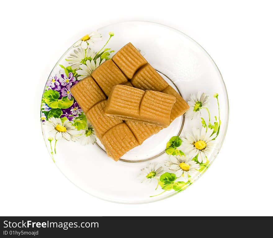 Several toffee in plate on tea saucer decorated flowers