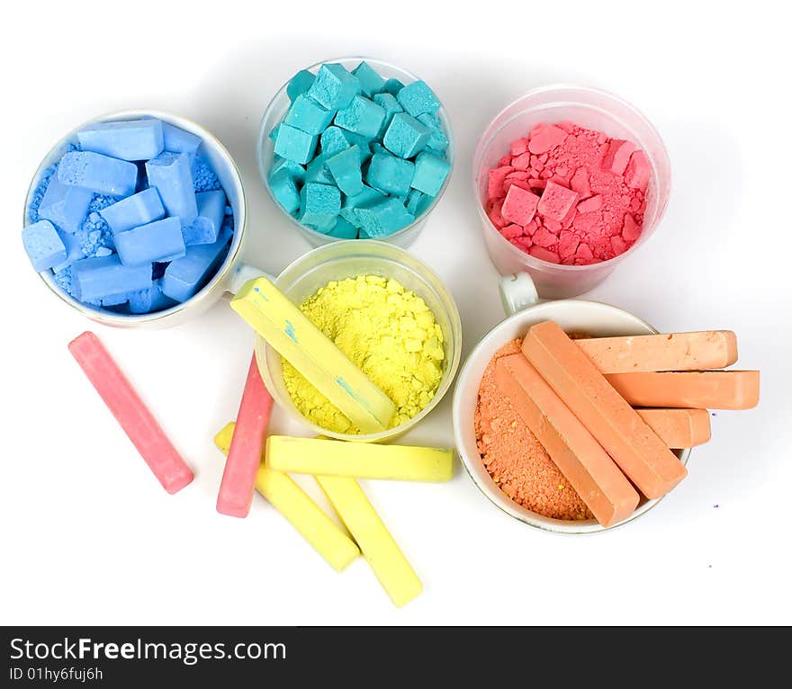 Several colors crushed chalk in tubes and caps on white