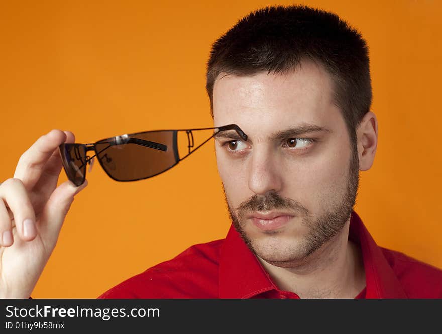 Young handsome man holding sunglasses