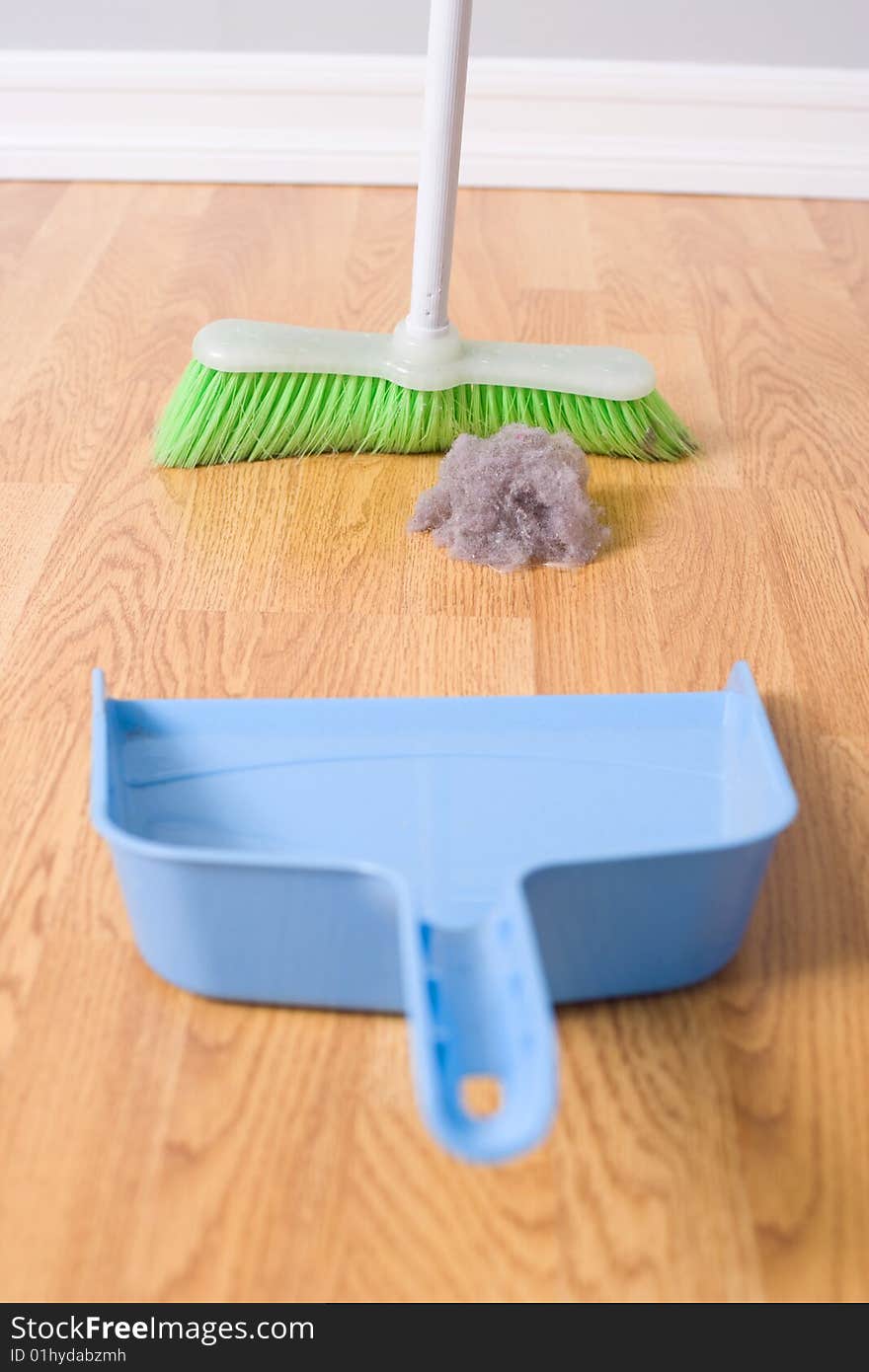 Spring Cleaning sweeping large dust bunny on a hardwood floor