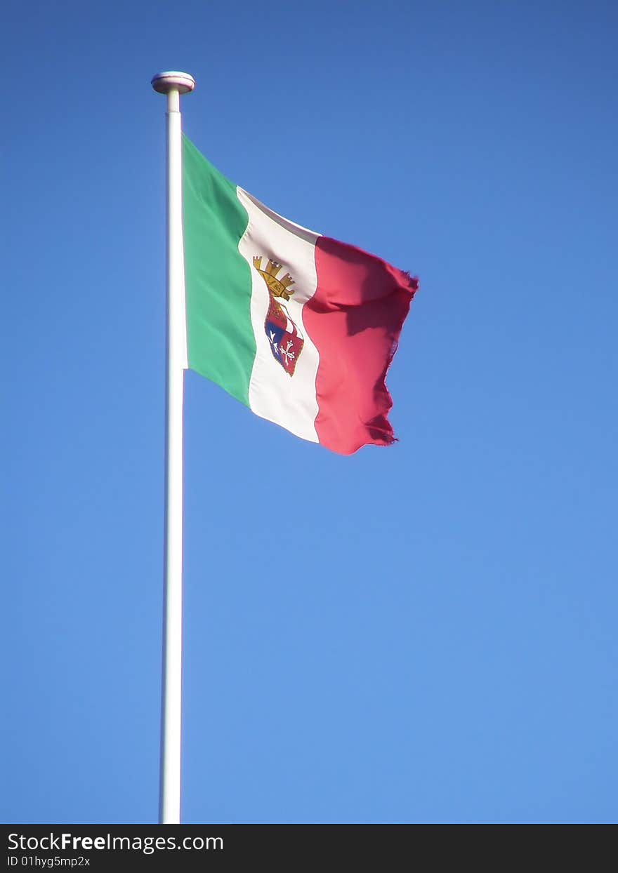 This is an italian navy flag in a blue sky.