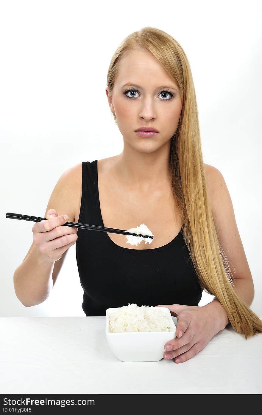 A woman use chopsticks eating Rice