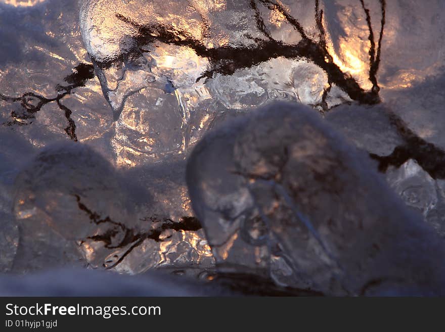 Sunset over frozen lake in winter, Finland, frozen branch detail