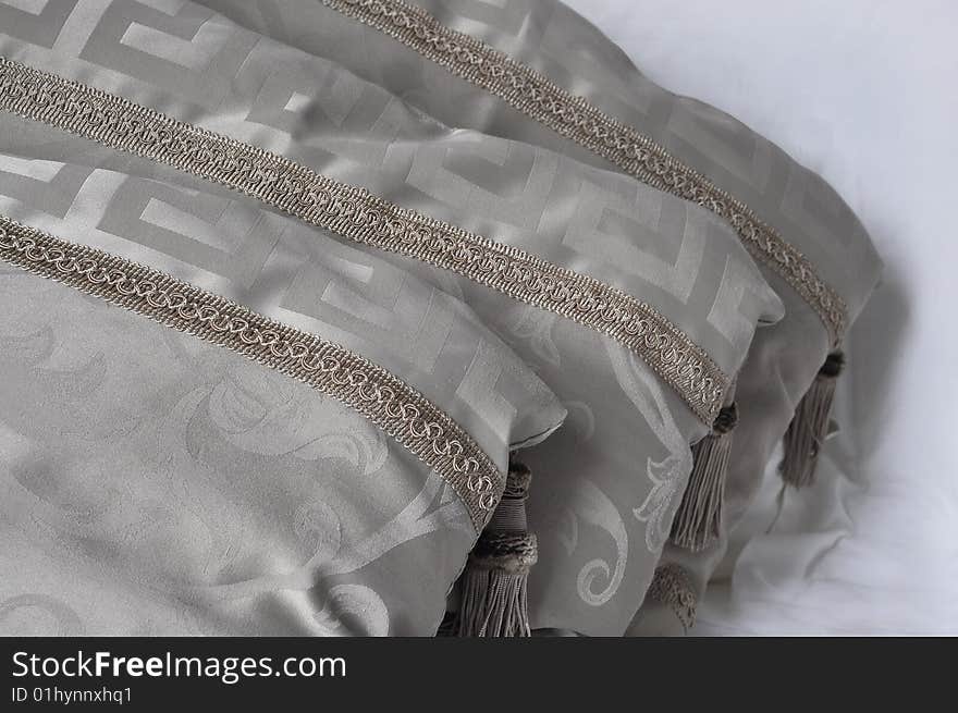 Three decorative beige pillows with tassels