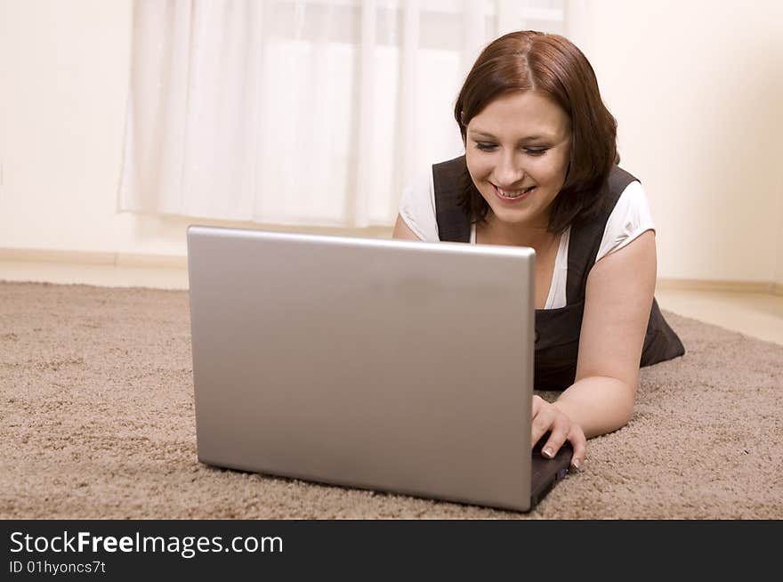 Woman with laptop on carpet