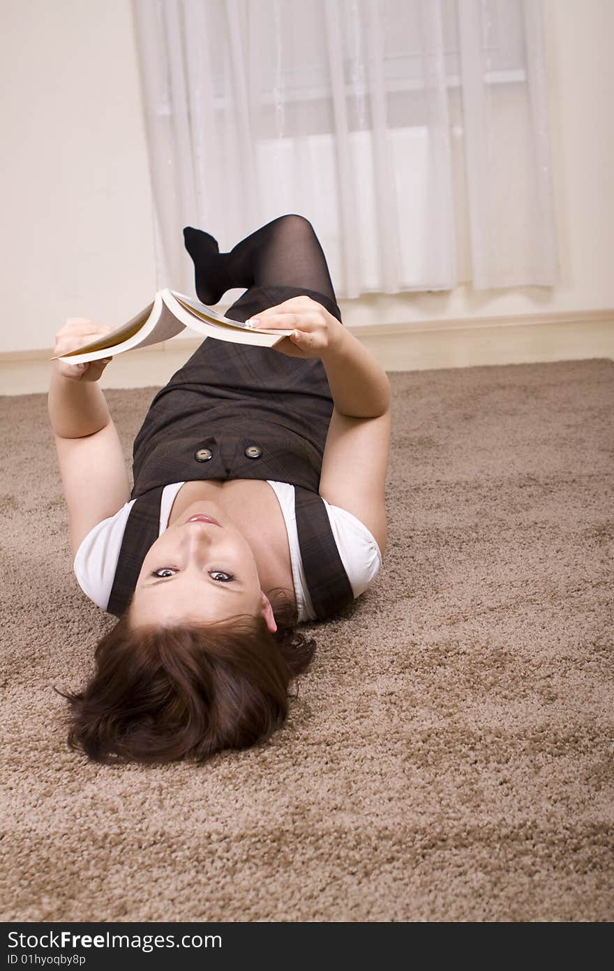 Woman reading a book on carpet. Woman reading a book on carpet