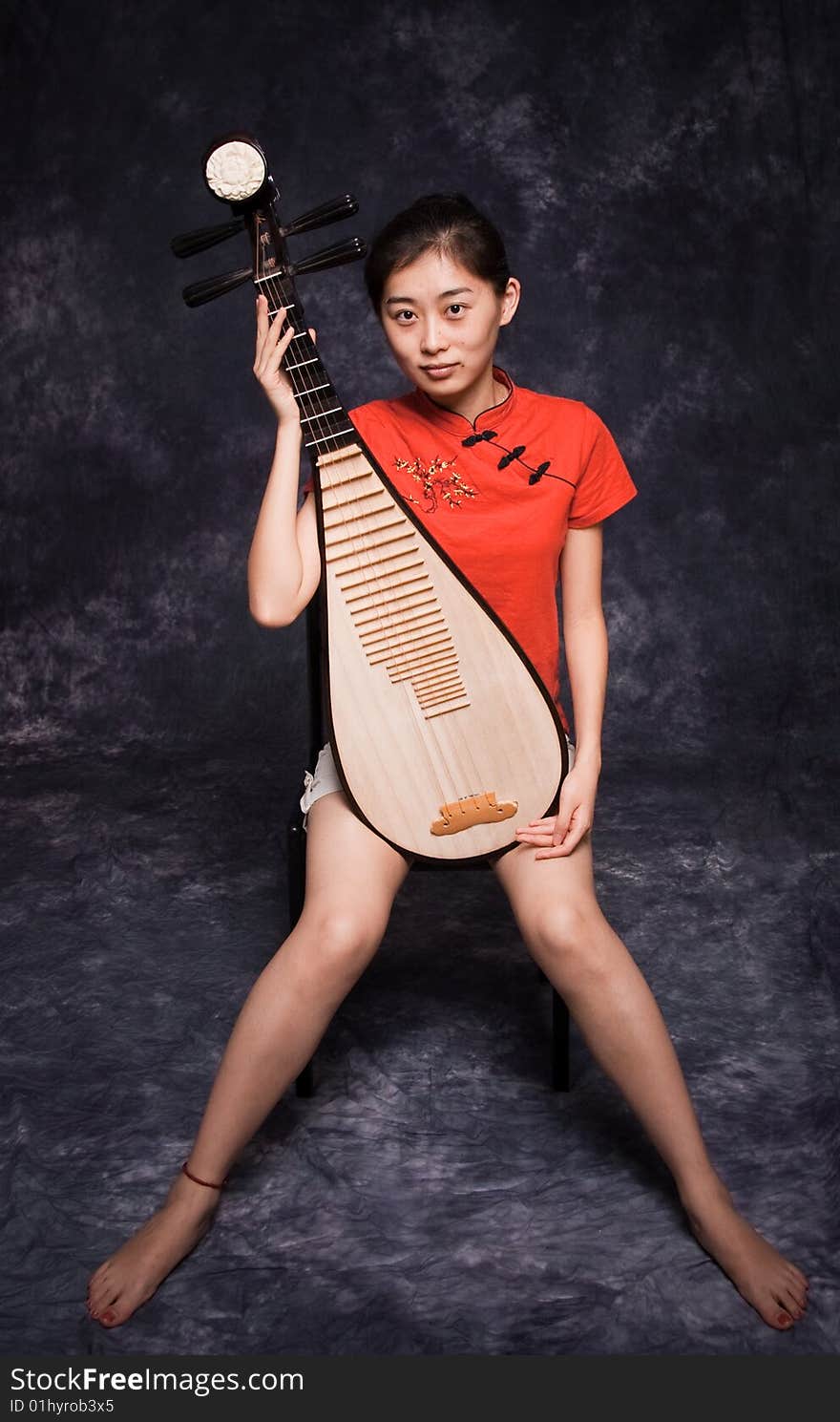 Chinese lute player in red shirt on performance. Chinese lute player in red shirt on performance