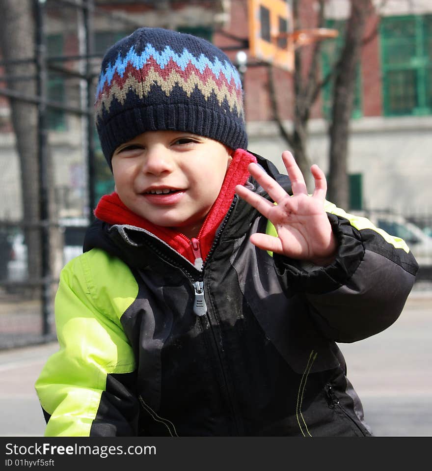 Portrait of a little boy waving into the camera