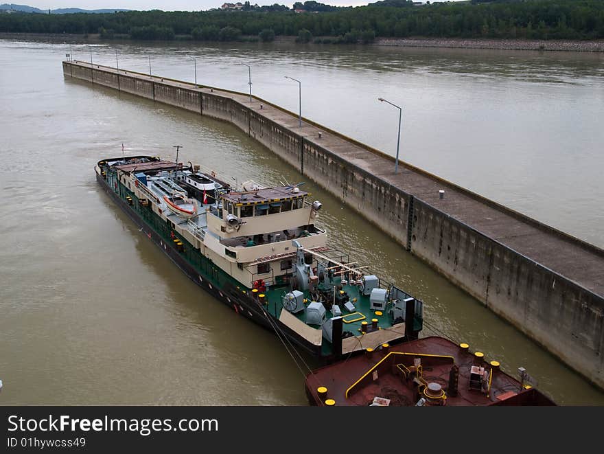 A tugboat entering the locks, pushing a barge, on the Danube River. A tugboat entering the locks, pushing a barge, on the Danube River