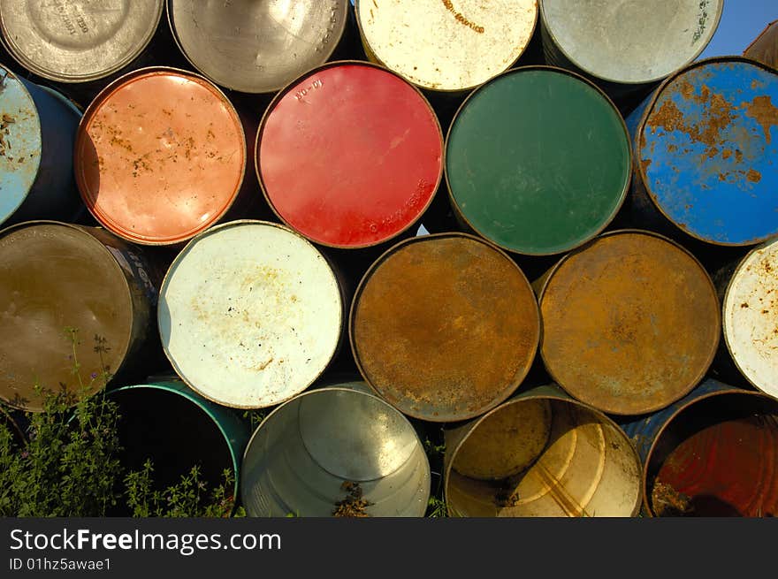 A stack of grungy old oil drums at a music festival, ready to be set out as rubbish bins. A stack of grungy old oil drums at a music festival, ready to be set out as rubbish bins.