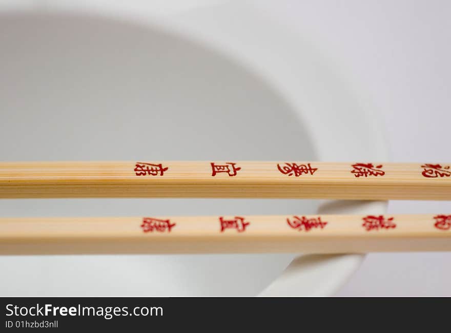 Chopsticks with Chinese or Japanese writing on a bowl , a detail