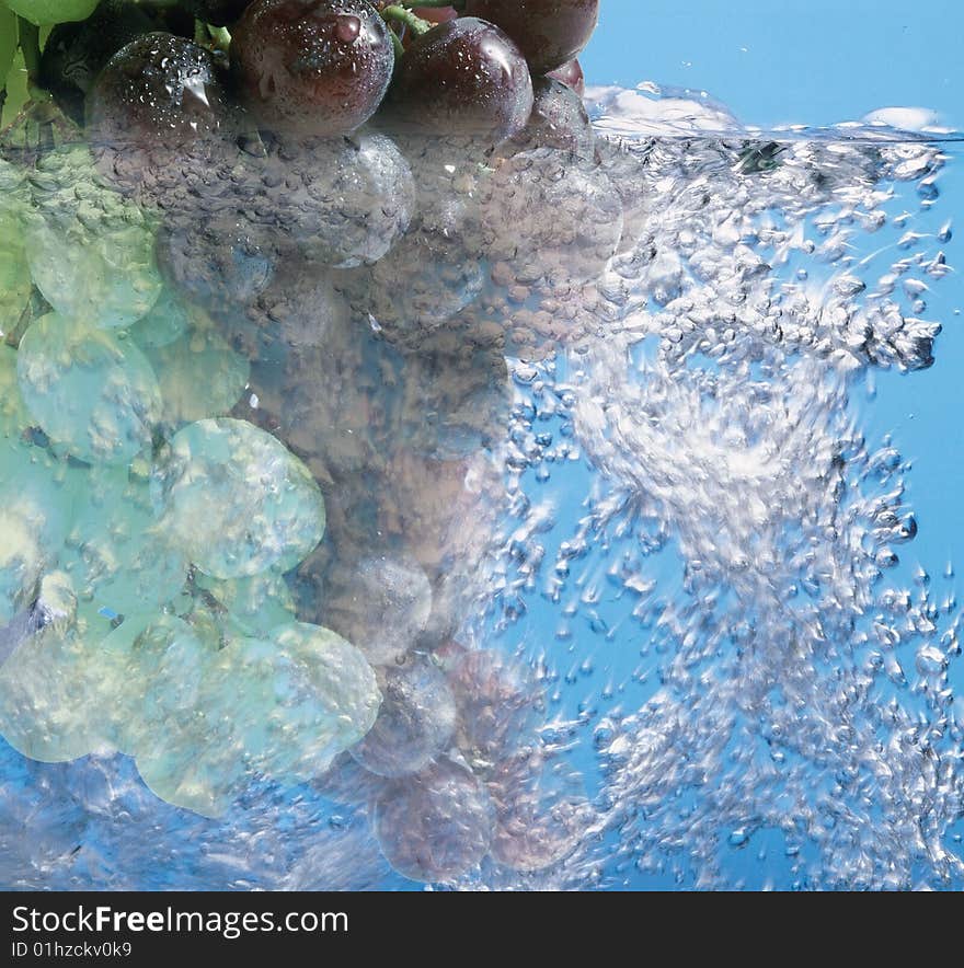 Beauty green and red grapes under water