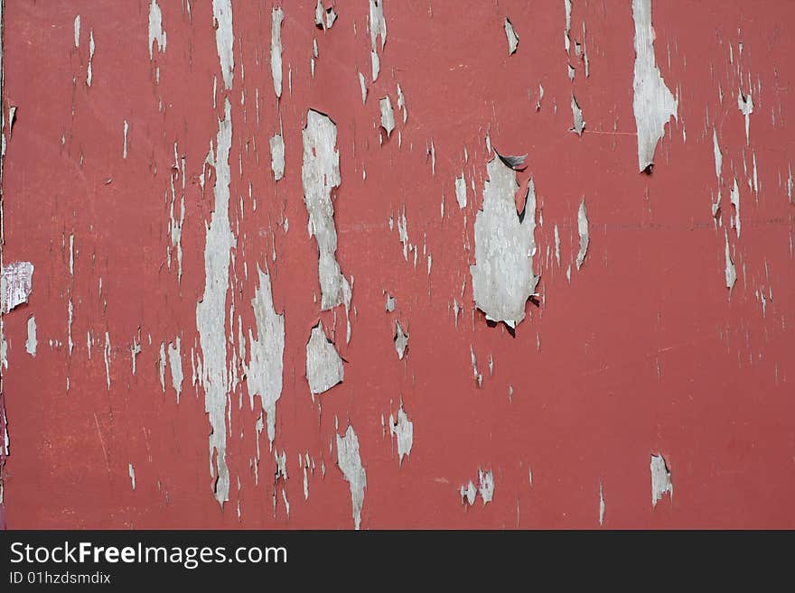 Cracked and peeling red paint on a wooden surface creating an interesting background. Cracked and peeling red paint on a wooden surface creating an interesting background.