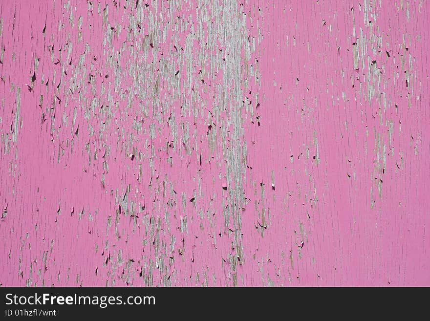 Cracked and peeling pink paint on a wooden surface creating an interesting abstract background. Cracked and peeling pink paint on a wooden surface creating an interesting abstract background.