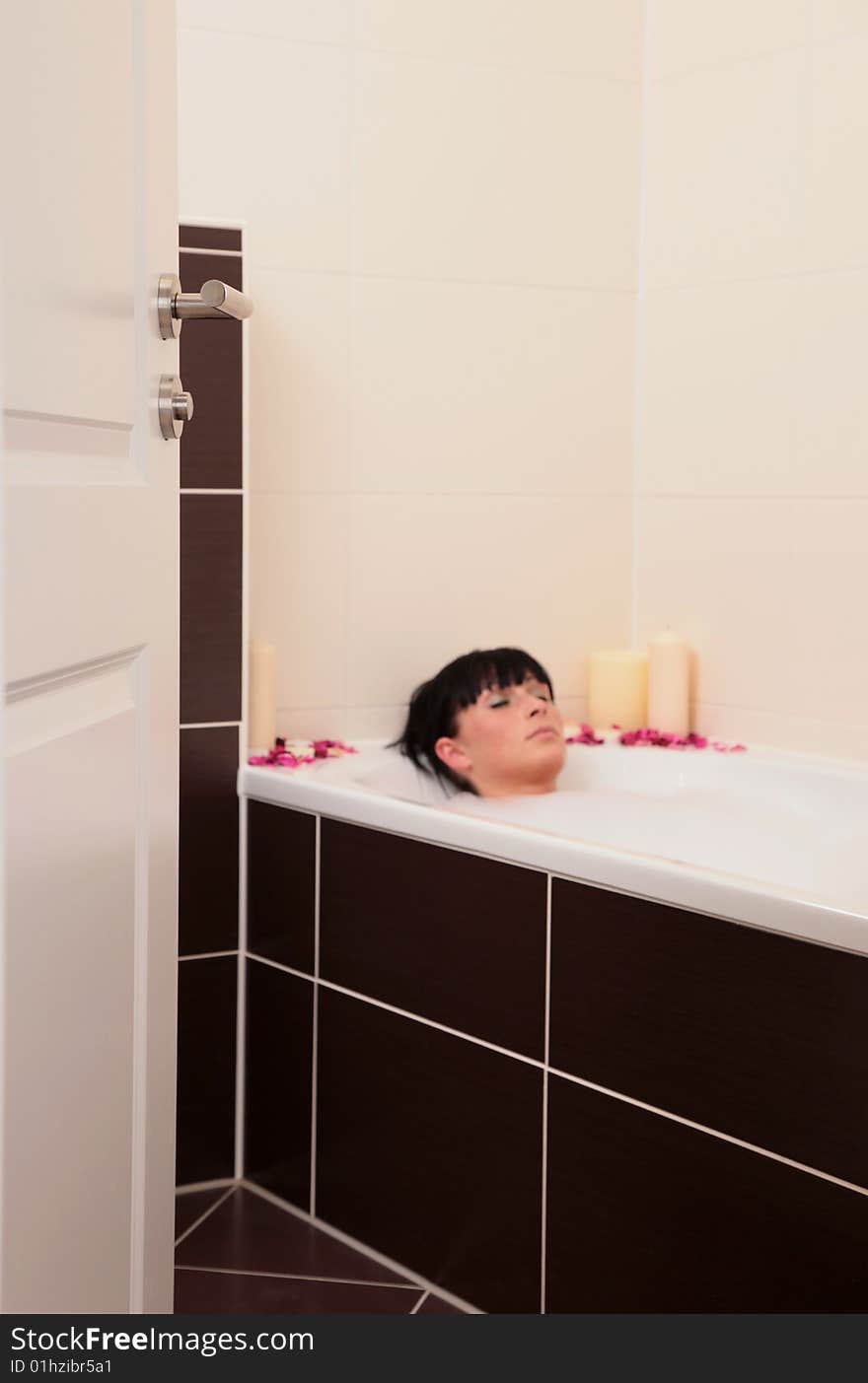 View on a bathing woman behind the door. focus on bathroom door