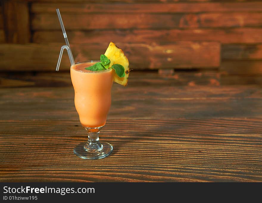 Cocktail smoothie with pineapple and mint on a wooden rack