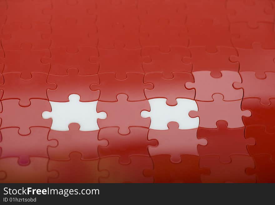 Red plastic puzzle with two white pieces. Red plastic puzzle with two white pieces