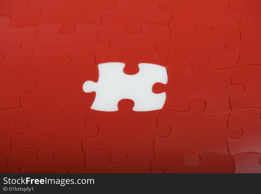 Red plastic puzzle with two white pieces. Red plastic puzzle with two white pieces