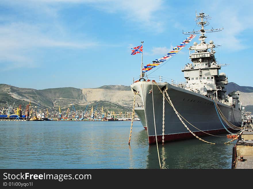 A battleship anchored in the harbour. The water is still