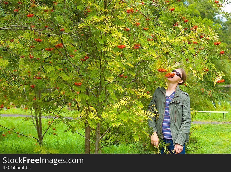 Man in the sunglasses eating orange ashberry. Man in the sunglasses eating orange ashberry.