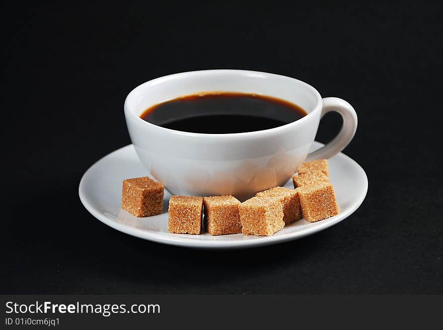 White cup of black coffee with sugar cubes