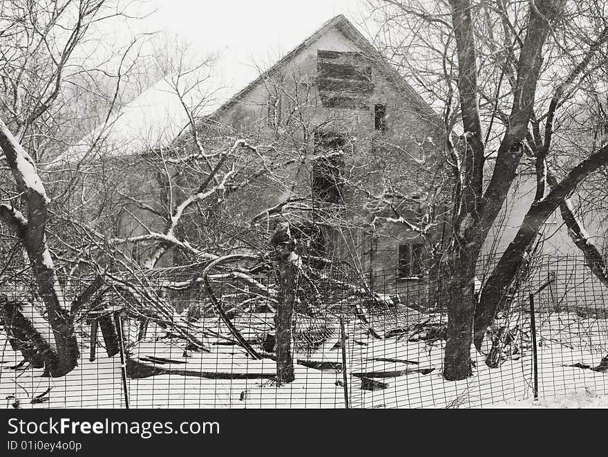 Black & white photo of an old farm house buried in the woods. snow, winter. Black & white photo of an old farm house buried in the woods. snow, winter