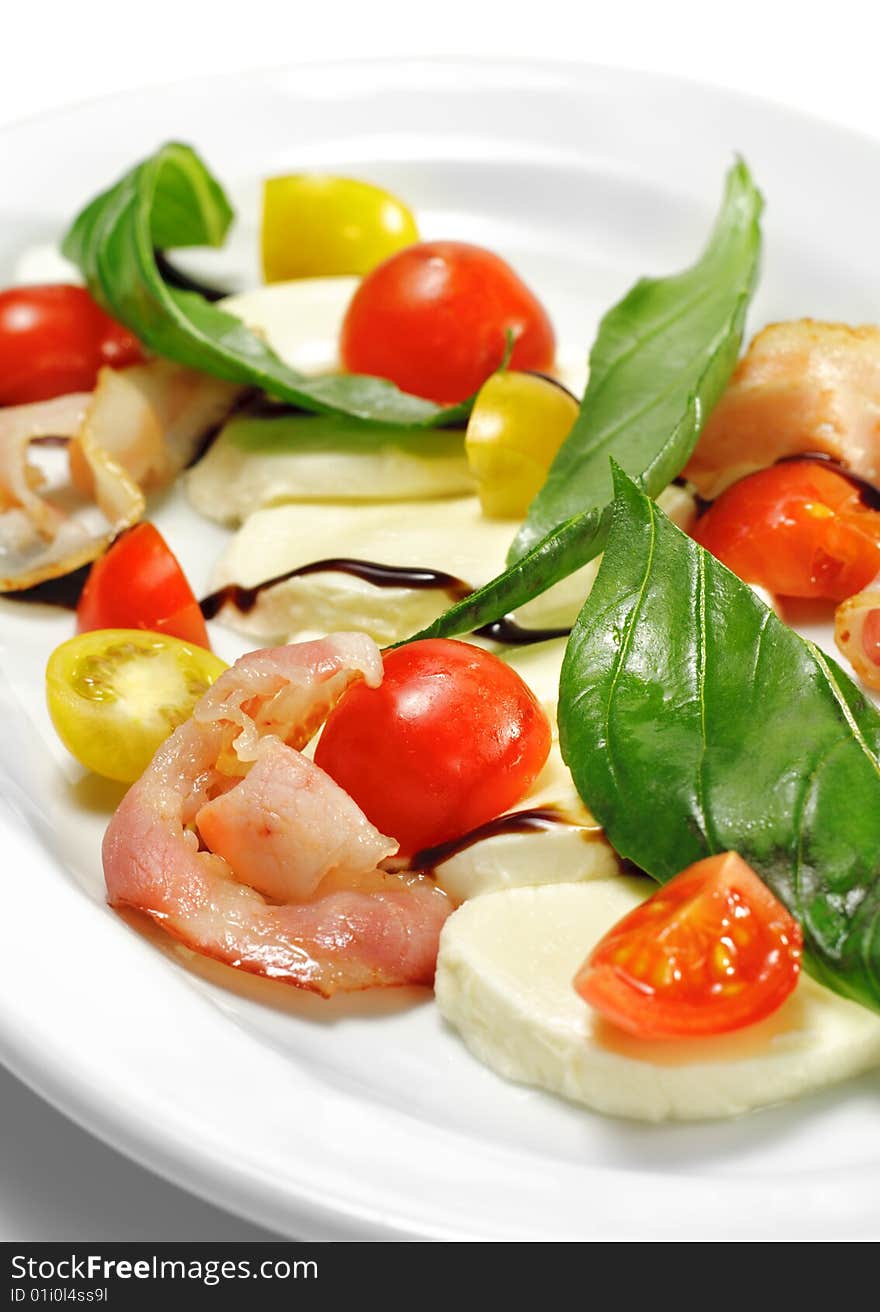 Salad with Cherry Tomato, Buffalo Cheese, Bacon and Vegetable Leaf. Isolated on White Background. Salad with Cherry Tomato, Buffalo Cheese, Bacon and Vegetable Leaf. Isolated on White Background