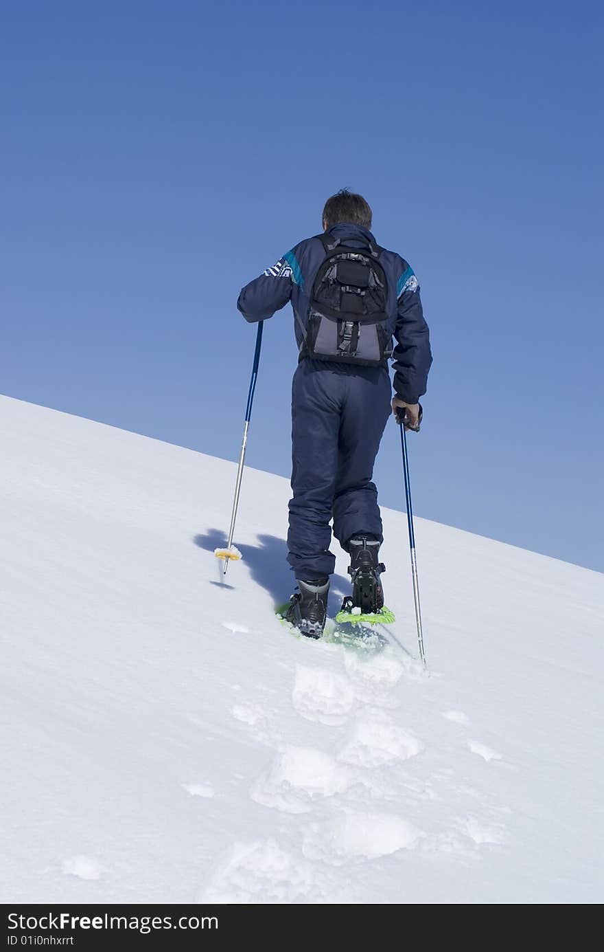 Man climbing a moutain with snowshoes. South of Alps (French Riviera)