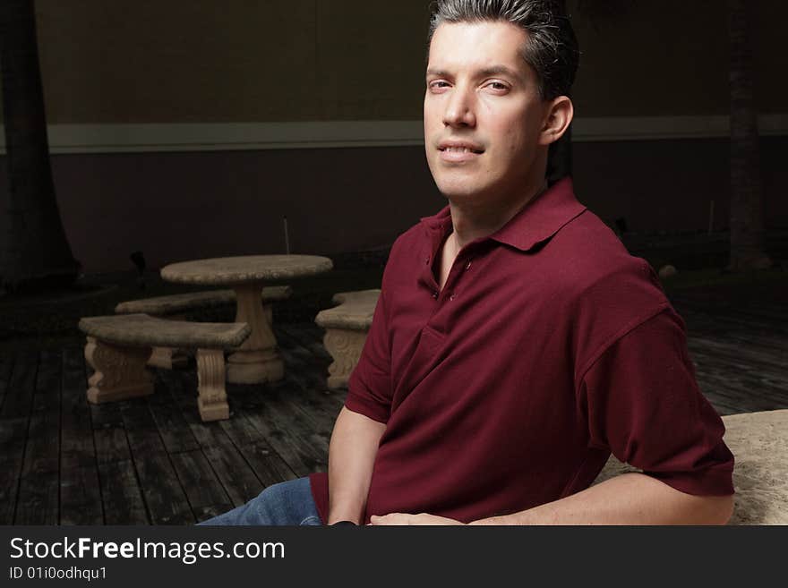 Handsome young businessman sitting at a park table. Handsome young businessman sitting at a park table