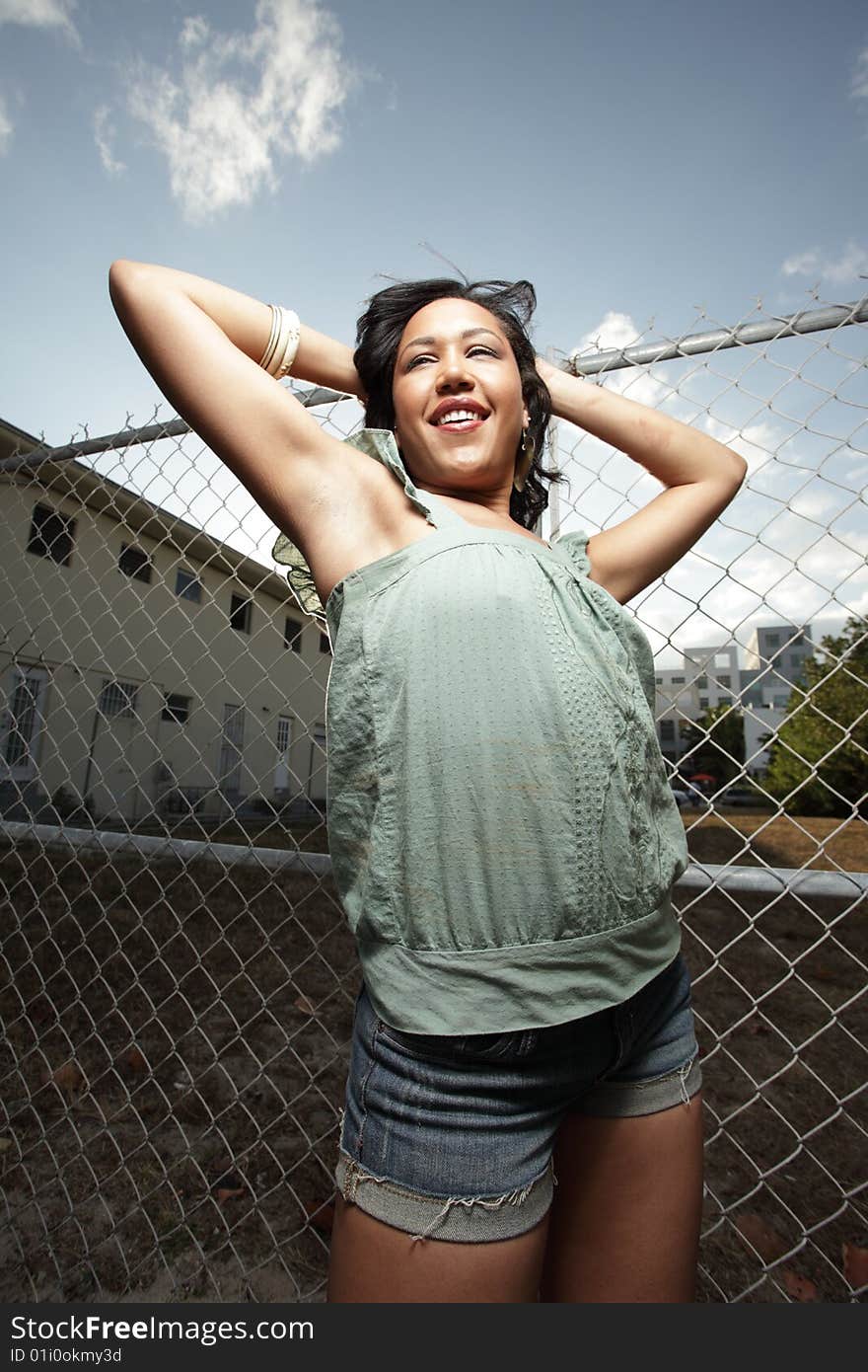 Young hispanic woman posing with her hands touching her head and smiling. Young hispanic woman posing with her hands touching her head and smiling