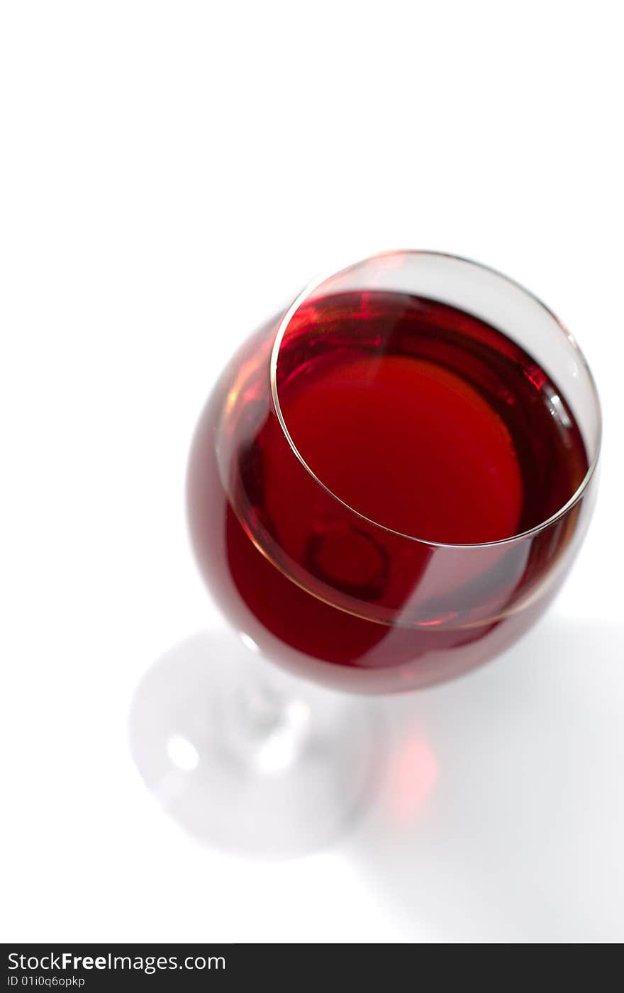 Bottle and glass of red wine on a white background