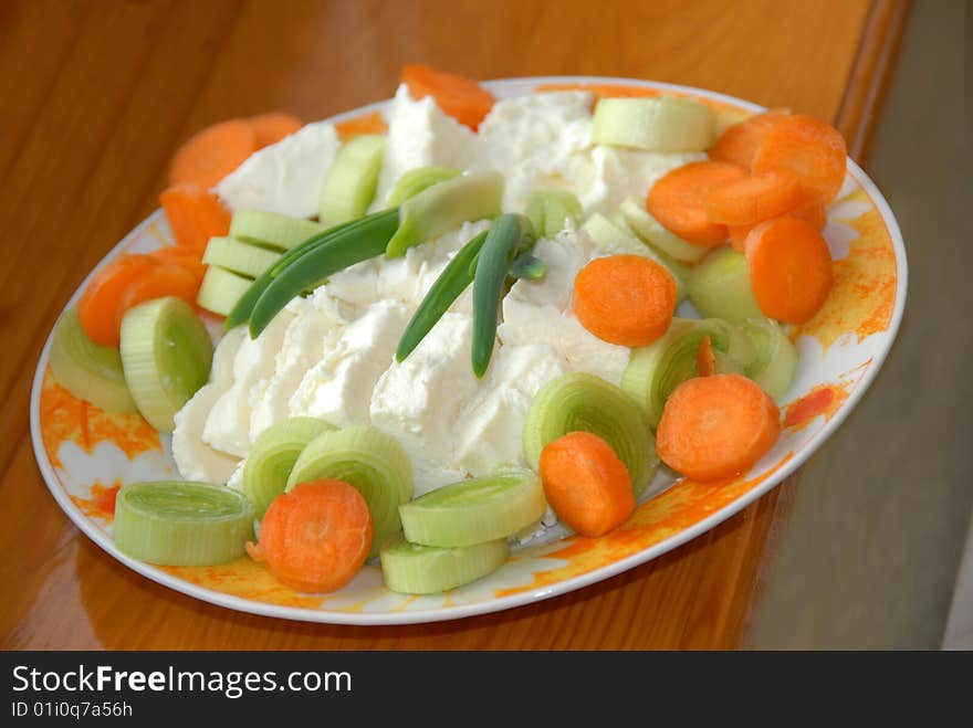 Cut green leek, carrot and white cheese slices closeup. Cut green leek, carrot and white cheese slices closeup