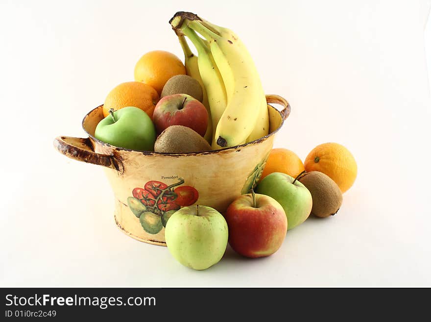 A basket filled with delicious fresh fruits with some in front of it. A basket filled with delicious fresh fruits with some in front of it