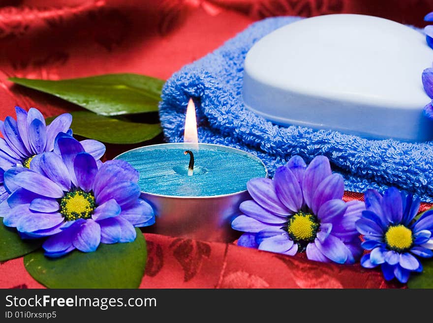 Spa essentials, soap, towel and candle with flowers