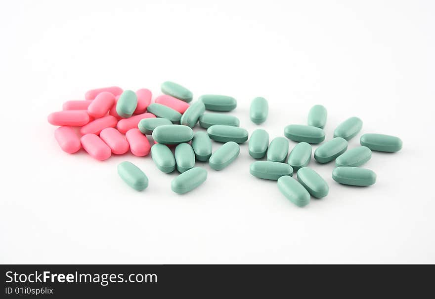 Pink and green pills displayed on white. Pink and green pills displayed on white