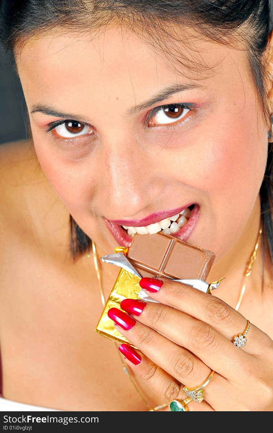 Indian girl eating chocolate bar