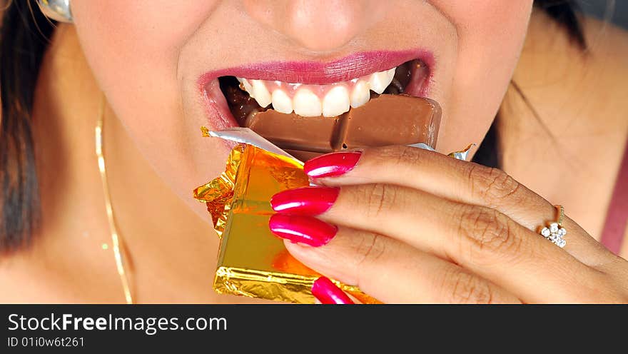 Indian girl eating chocolate bar