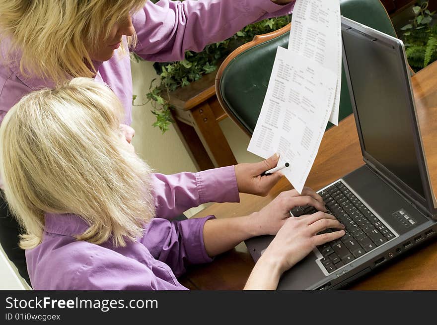 Women working together on a project using a laptop. Women working together on a project using a laptop