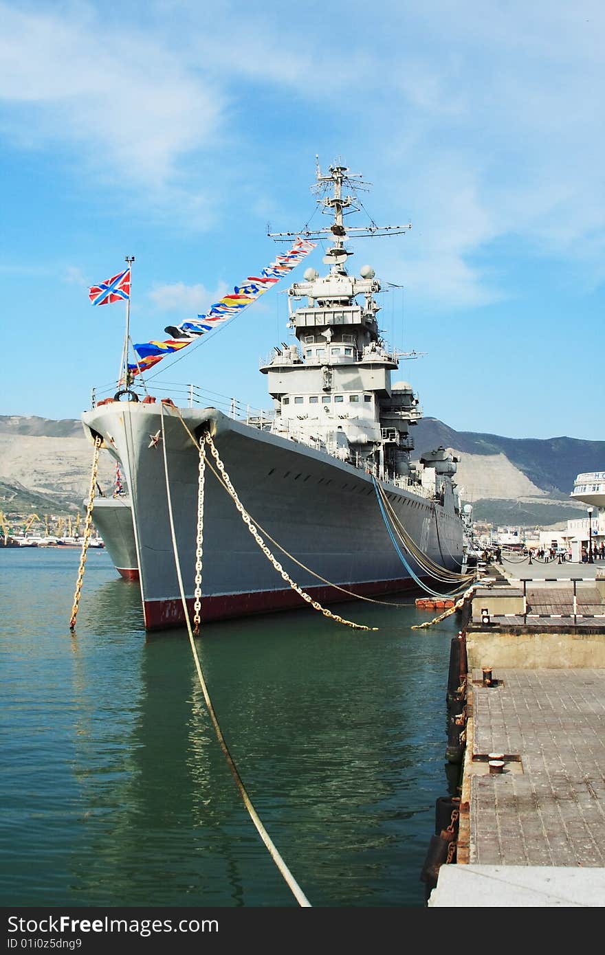 A battleship anchored in the harbour. The water is still