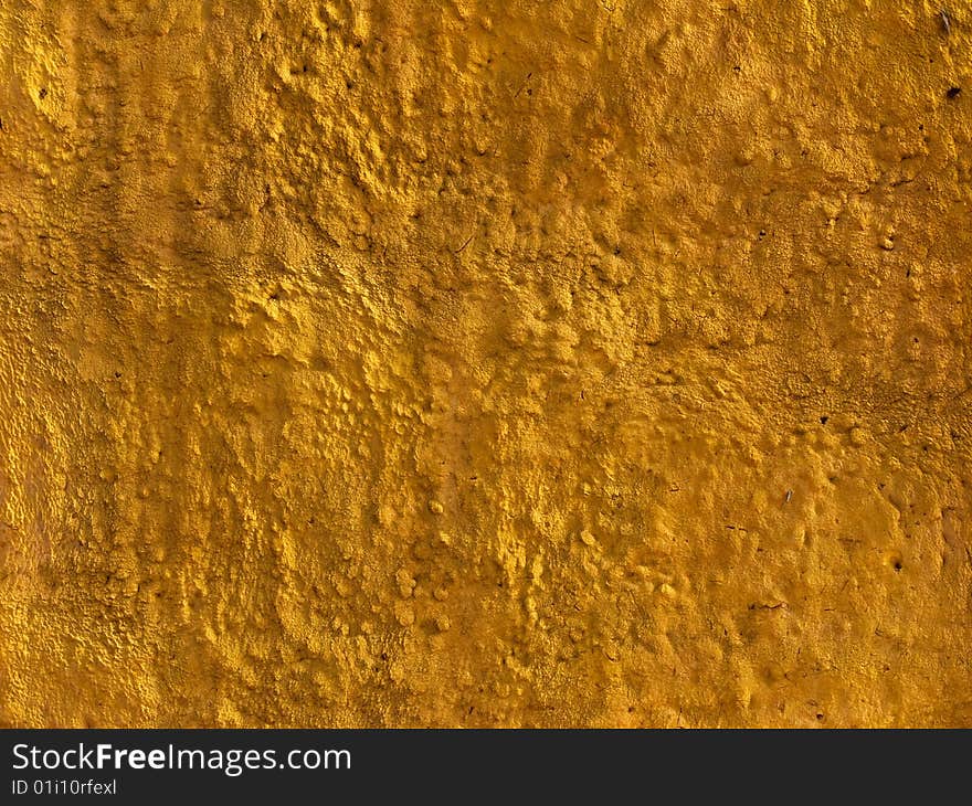 Fragment of yellow concrete wall protective covering surface. Fragment of yellow concrete wall protective covering surface