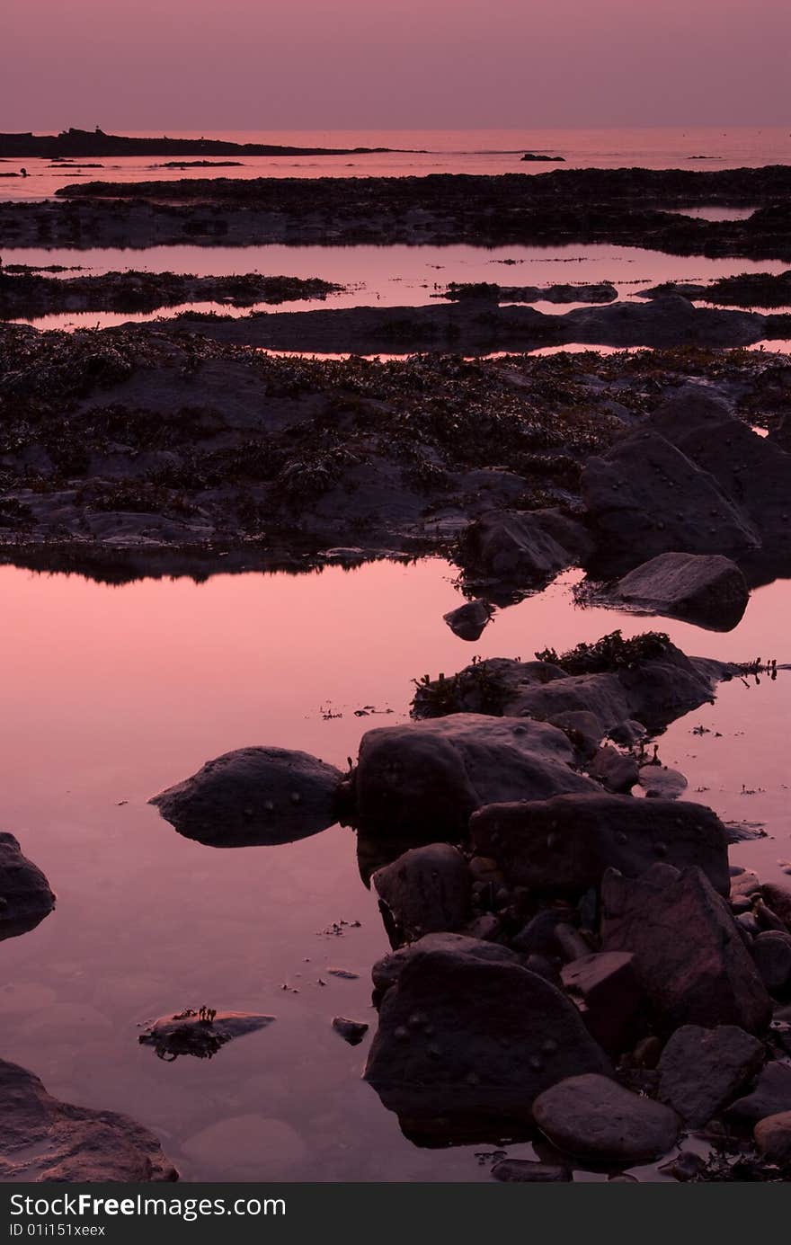 Pale purple sunrise over rockpools